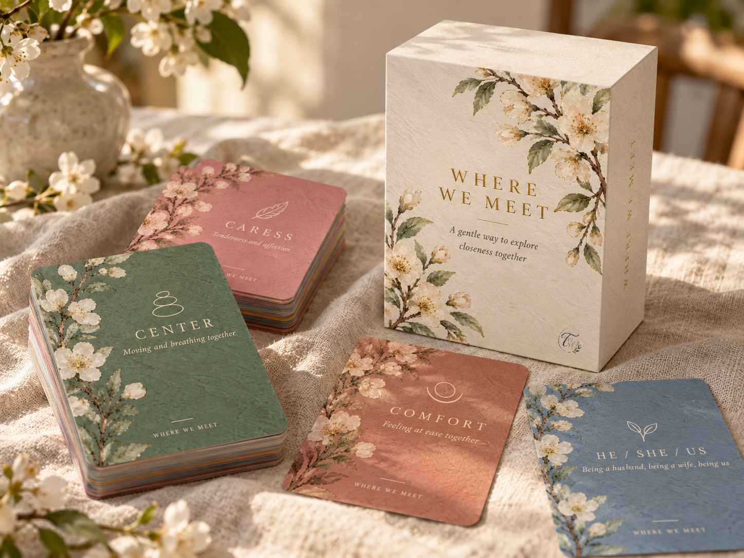 The Where We Meet card deck, with its box and four cards laid on a cloth.